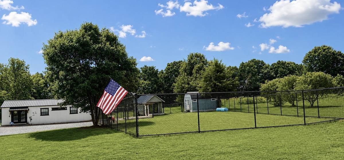 The Dandelion Paws office and boarding buildings with the fenced play yard